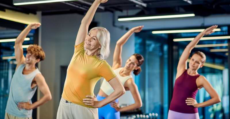 Trzy kobiety i jeden mężczyzna uprawiające fitness